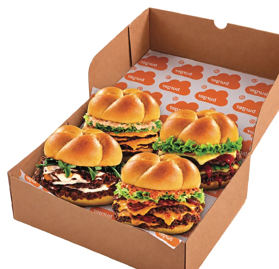 Quatre smash burgers Nūage dans leur boîte kraft