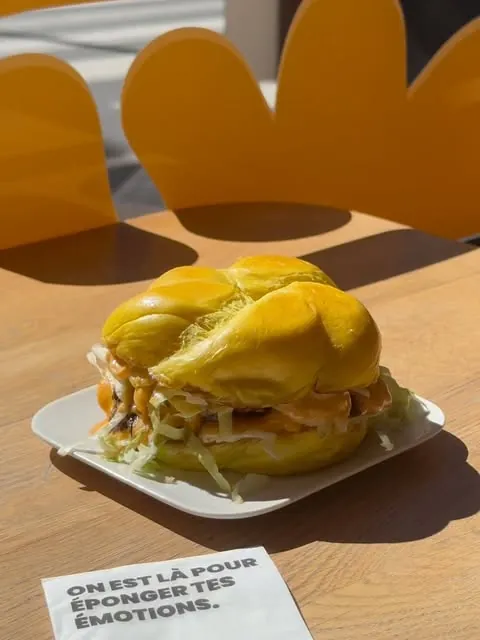 Burger sur une table devant les nuages orange du restaurant